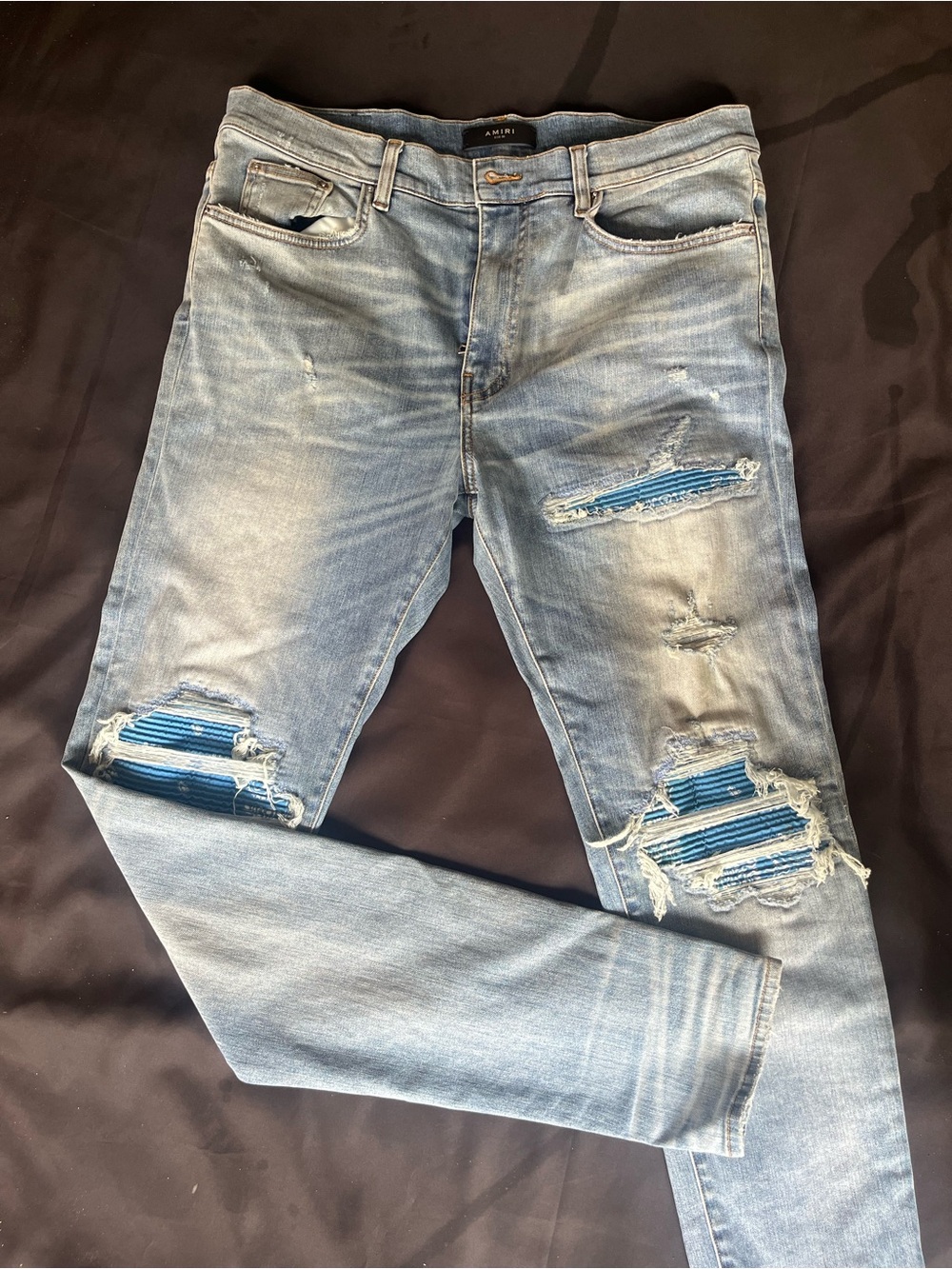 AMIRI Light Blue Distressed Skinny Jeans with Blue Patch Accents
